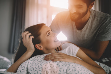 Intimate sensual young couple in bedroom enjoying each other.