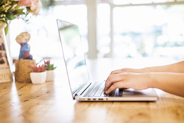 Close-up of business female working with laptop and smartphone in coffee shop like the background