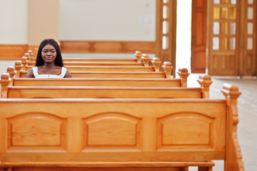 African american woman praying in the church. Believers meditates in the cathedral and spiritual...