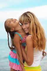Mom and daughter in the summer. Relax on the beach. Mother and daughter are resting near the sea....