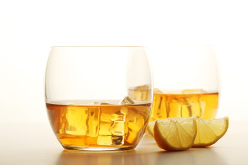 Two glasses with whiskey with ice cubes