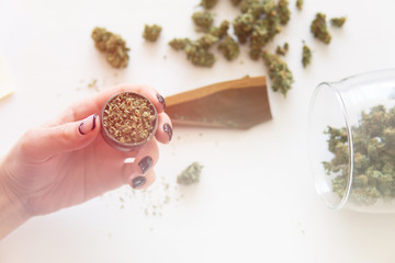 Woman preparing and rolling marijuana cannabis joint. marijuana use concept. Woman rolling a...
