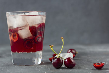 Fresh cherry cocktail. A cocktail with gin or vodka, cherry syrup and pieces cherry and ice