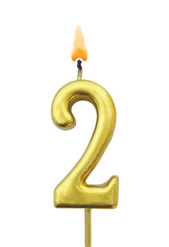 Burning golden birthday candle isolated on white background, number 2