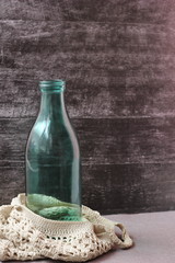 The glass bottle is in a knitted bag. Reusable packaging. Copy space.