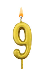 Burning golden birthday candle isolated on white background, number 9