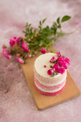 Fototapeta na wymiar Beautiful pink cream and berries cake on a light concrete background. Birthday celebration