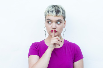 Young blond woman doing ok sign with fingers, showing hush sign with serious expression,showing stop gesture, excellent symbol, isolated over white background