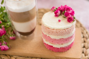 Beautiful pink cream and berries cake on a light concrete background. Birthday celebration