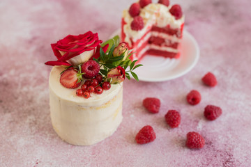 Beautiful pink cream and berries cake on a light concrete background. Birthday celebration