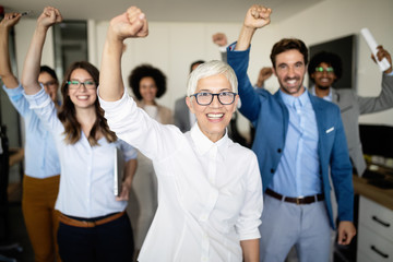 Happy business people celebrating success at company