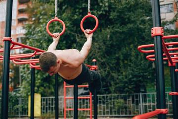 Fototapeta na wymiar Man training. Guy in a sports shorts. Male in a summer park