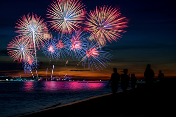 Amazing beautiful colorful fireworks display on celebration night, showing on the sea beach with...