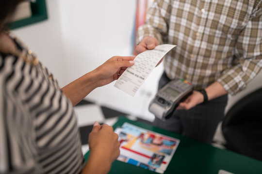 Close-up photo of seller handing the receipt to the customer