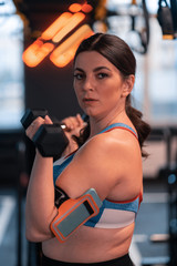 Fototapeta premium Dark-haired woman with overweight working out in gym