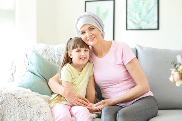 Mature woman after chemotherapy with her granddaughter at home