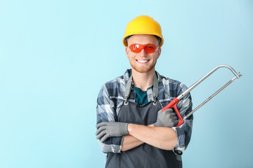 Male carpenter on color background