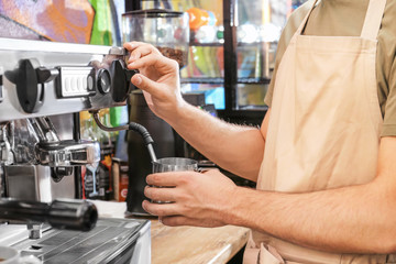 Barista preparing fresh aromatic coffee in cafe