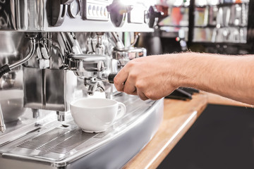 Barista preparing fresh aromatic coffee in cafe