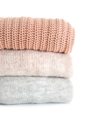 Stack of warm clothes on white background