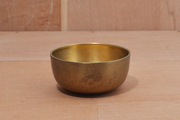Ancient brass bowl for special ceremony on wooden table. alloy bowl rubbed with stone, handmade product of thailand