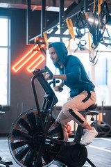 Handsome businessman wearing sport clothing cycling in gym