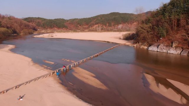 Aerial takeover of tiny wooden bridge at 45 degree angle
