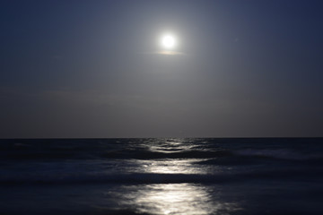 The moon reflects on the sea and illuminates the night