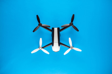 A drone on blue background, shot from above, aligned in the center.