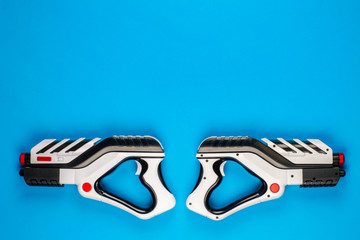 Two pistols on blue background shot from above.