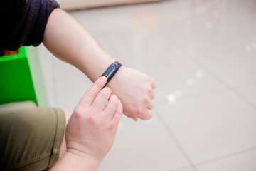 Man is wearing a fitness bracelet. Smart watch on the hand of a man. Pensioner Using Fitness Tracker.