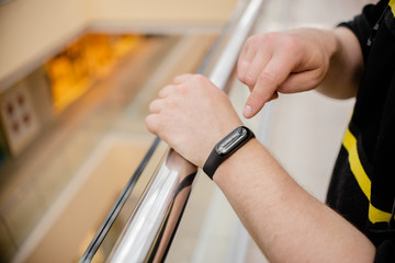 Obraz premium Man is wearing a fitness bracelet. Smart watch on the hand of a man. Pensioner Using Fitness Tracker.