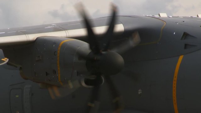A propeller of an Airplane spinning. The engines shut of and the propeller spins slower. Sunny day, clouds in the background.