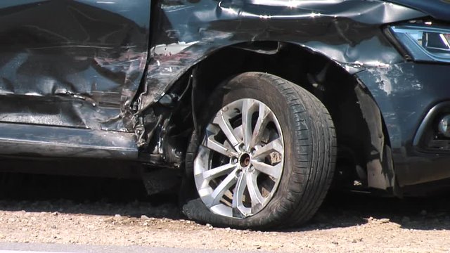 Vehicle Damaged After Auto Collision. Dark Grey Car Crash in Front After the Accident. Side View Midle Shoot of a Crashed Car.