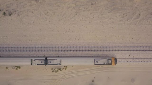 Passenger train birds eye view fast pass by with dust trail (4K)