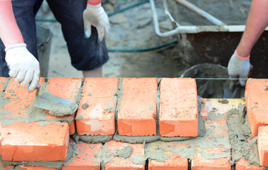 Masonry house wall construction.Bricklayers hands bricklaying house wall