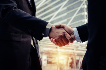 Partnership. close up business man in modern suit hands shaking after finishing up a business...