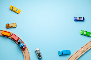 Children's railway with wooden rails and cars on a blue background, top view. Copy space for text.