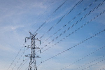 High voltage post tower with blue sky before sunset