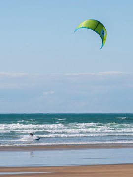 A kiteboarder on the sea at a shallow beach in Devon, UK