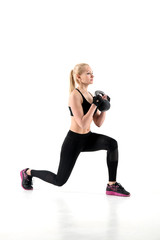 The athlete performs an exercise lunges with a weight in her hands.