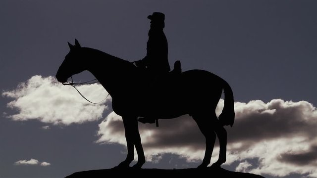 Silhouette of Horse and Rider Statue Over Cloudy Sky. Fast Motion.