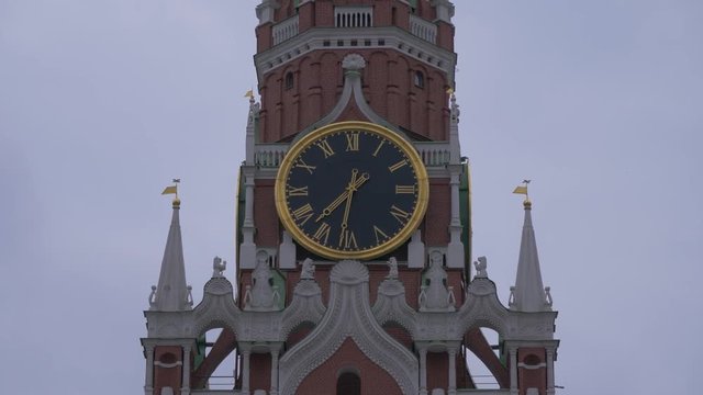 Clock on Spasskaya Tower on Red Square under a gloomy sky on a gray cloudy day. Close up