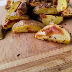 pieczone ziemniaki z kminkiem na drewianej desce