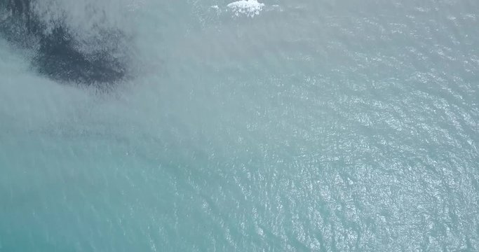 NATURE 4K Beach aerial top down view of ocean surface to white sandy beach and vegetation with a twisty dirt road