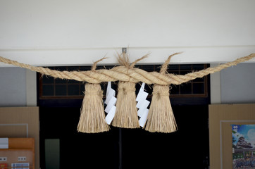 It's a sacred rope or shimenawa". It is used for separating a holy place from other unclean places.