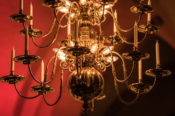 gold-plated chandelier hangs in the old church near the icons. Modern lamps are like candles.
