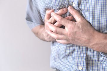The young man is suffering from chest pain. Chest spasm, angina pectoris. Heart attack.