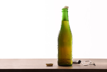 Green glass bottle with sparkling liquid and white background