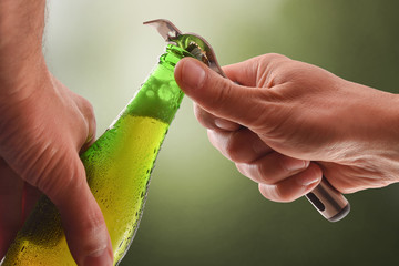 Hands open a beer can with bottle opener